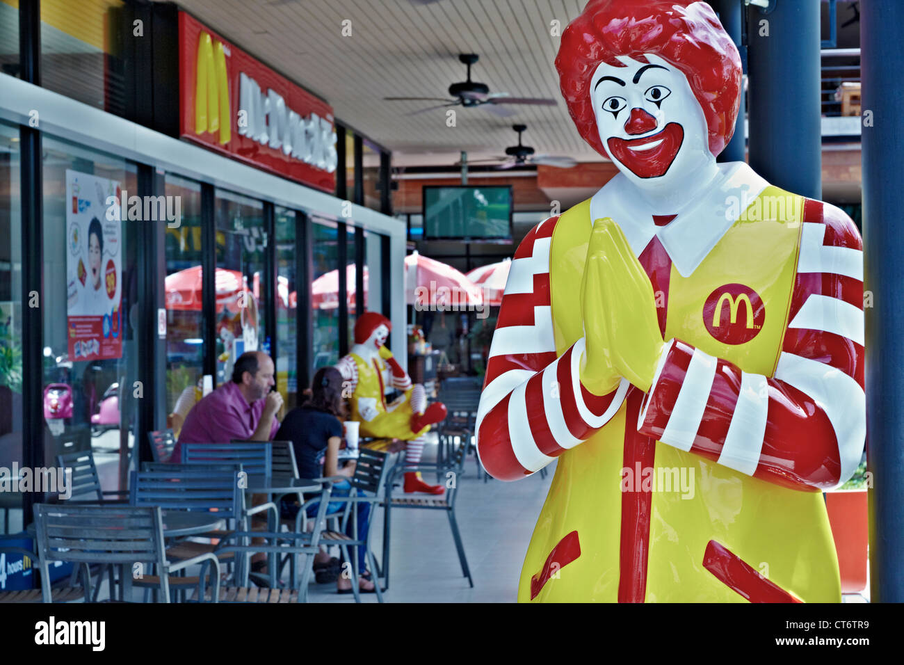 McDonald's restaurant in Thailand with Ronald McDonald greeting customers with the traditional Thai Wai. Thailand S. E. Asia. Stock Photo