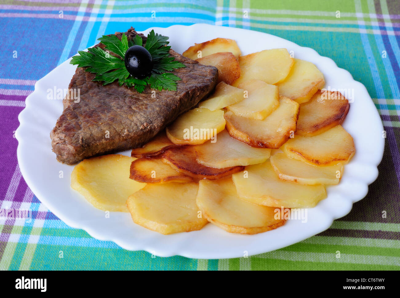 Veal with fried potatoes on a plate Stock Photo