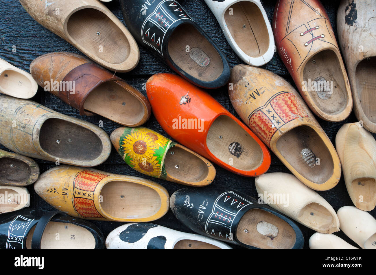 traditional wooden shoes in all sizes and colors hanging on a wall Stock Photo