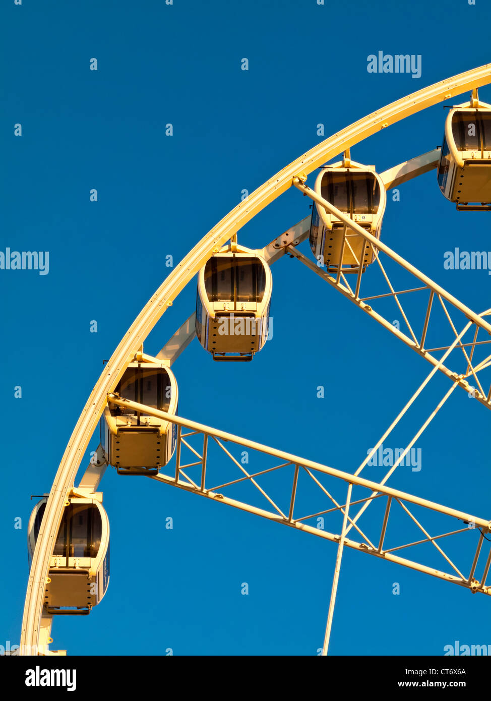Detail Of Large Ferris Wheel With Enclosed Cabins And Blue Sky