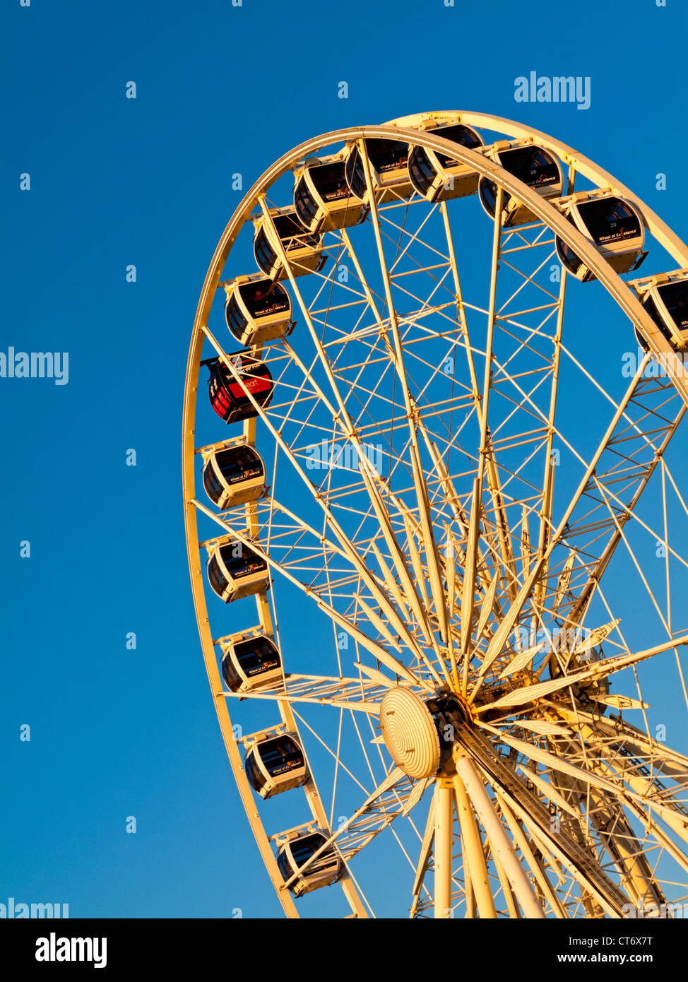 Detail Of Large Ferris Wheel With Enclosed Cabins And Blue Sky