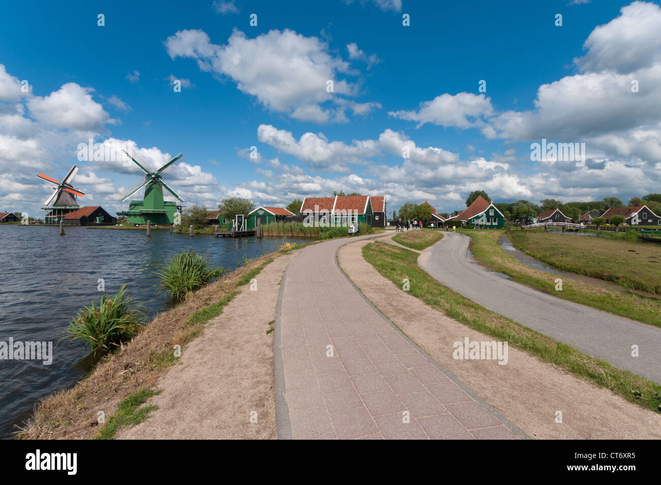 road along the water with the famous windmills of the zaanse schans Stock Photo