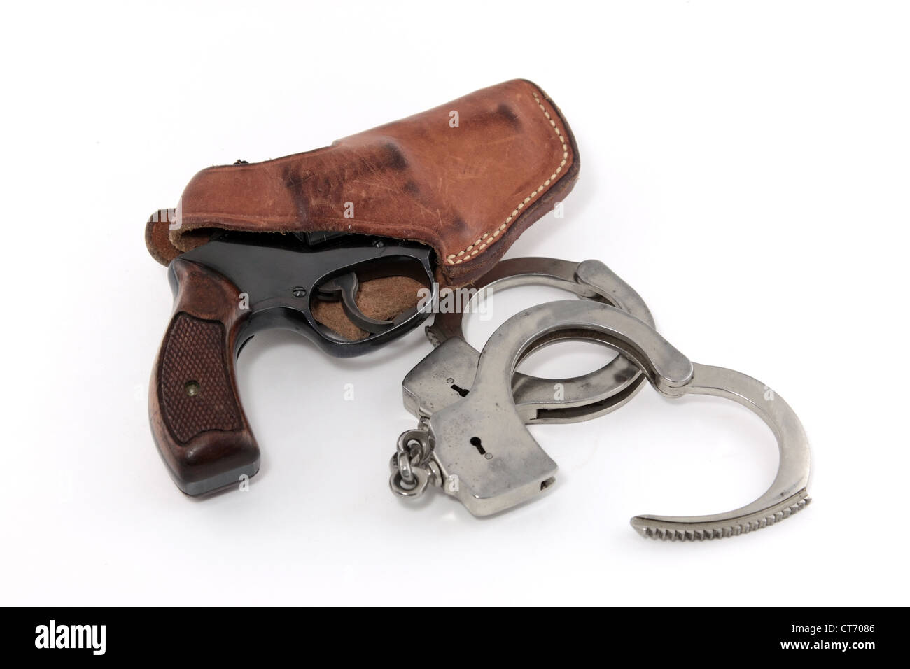Vintage revolver in leather holster with handcuffs on white background Stock Photo