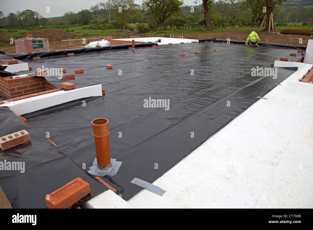 Laying DPC membrane on ESP polystyrene on passive slab foundation Colemans Hill Farm new build Mickleton Chipping Campden UK Stock Photo