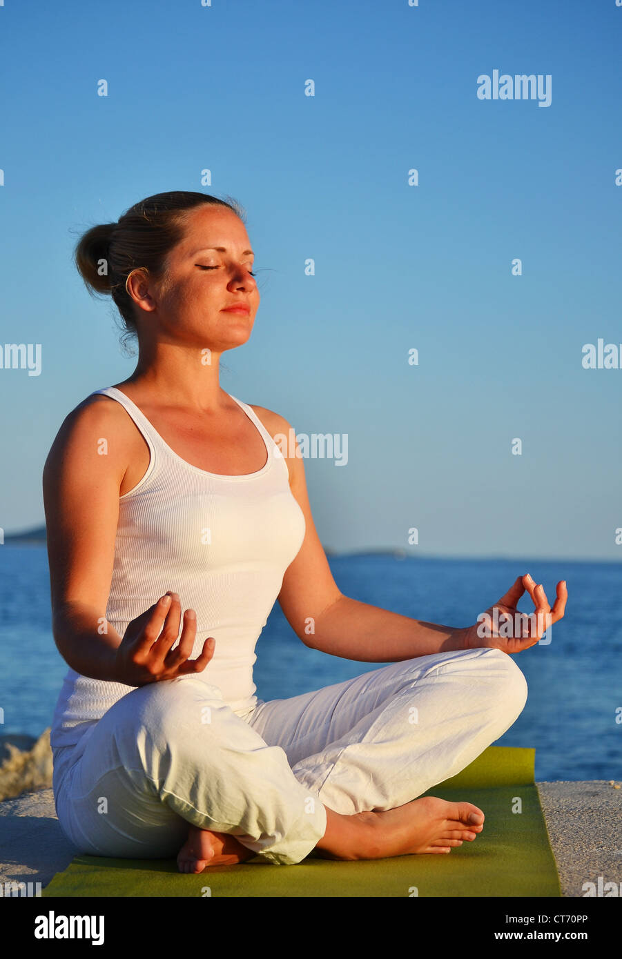 Young woman during yoga meditation on the beach Stock Photo - Alamy