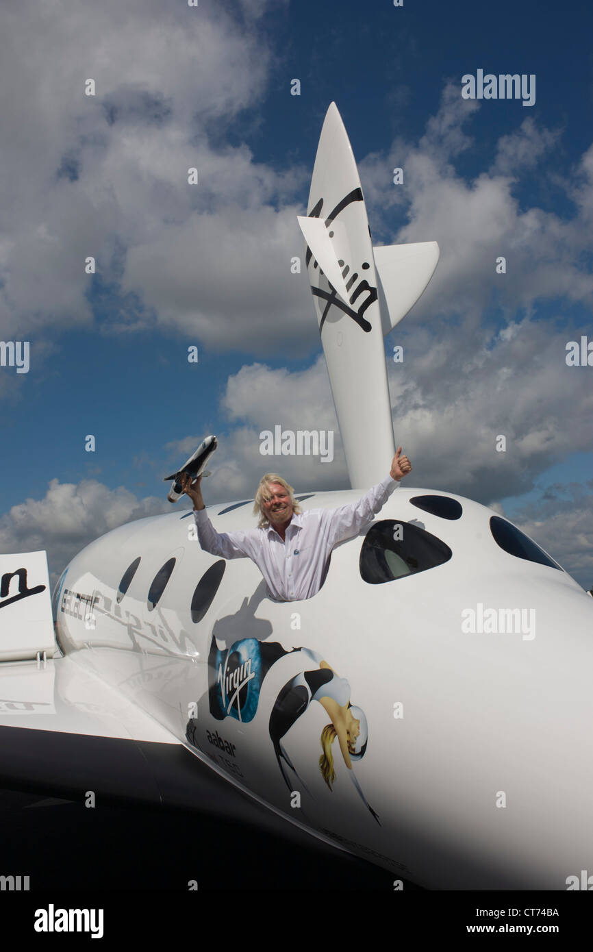 Alongside his SpaceShipTwo vehicle, Richard Branson holds model of satellite LauncherOne after Virgin Galactic space tourism presentation at Farnborough Air Show. Stock Photo