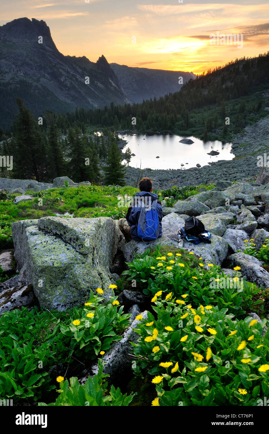 hiker watching sun rising over hudojnikov lake and camel rock Stock Photo