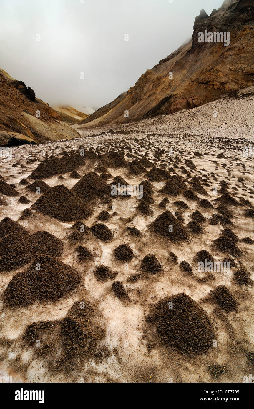 earth cones on snow field in Mutnovsky volcano area on Kamchatka Stock Photo