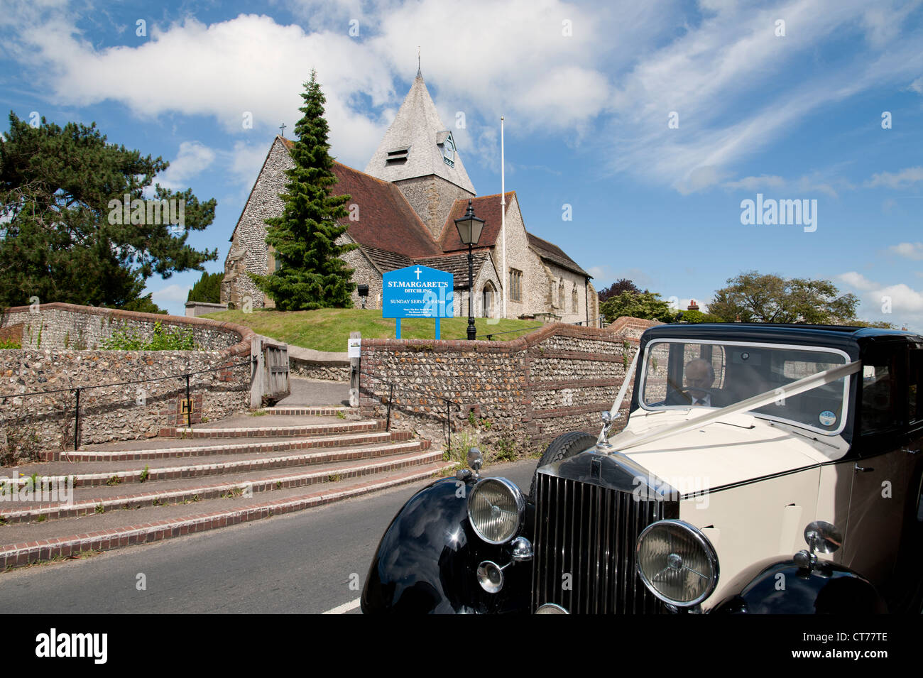 Vintage wedding car waiting outside St Margarets Church in Ditchling, Sussex, England, UK Stock Photo