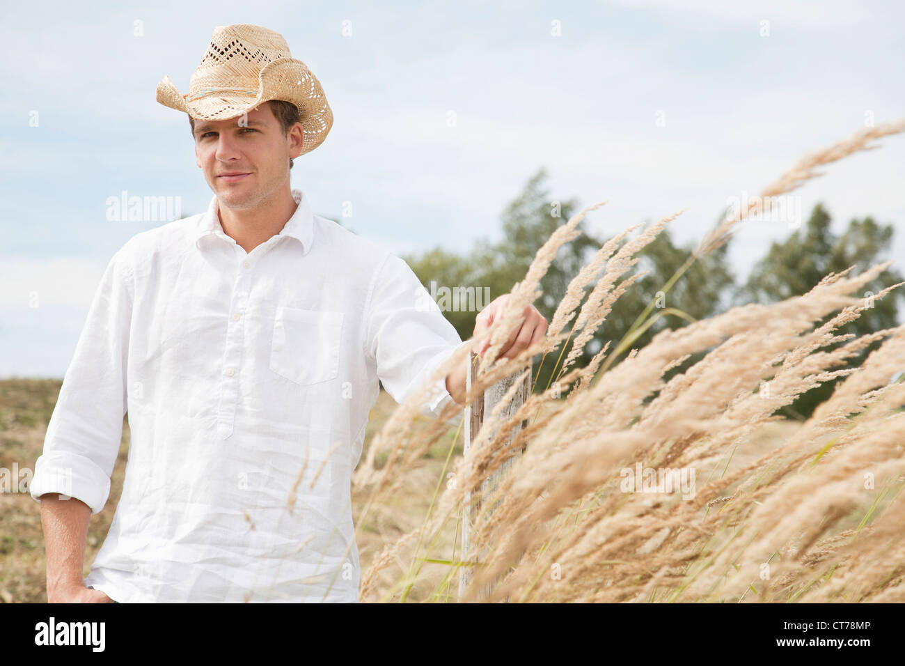 portrait of young man with straw hat in field Stock Photo - Alamy
