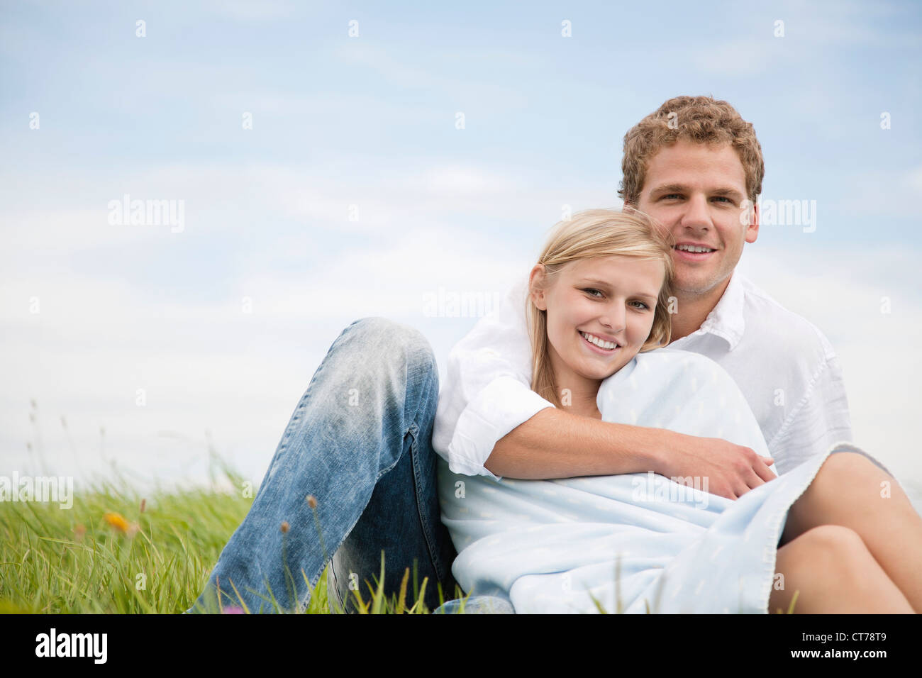 portrait of young couple sitting in grass Stock Photo - Alamy