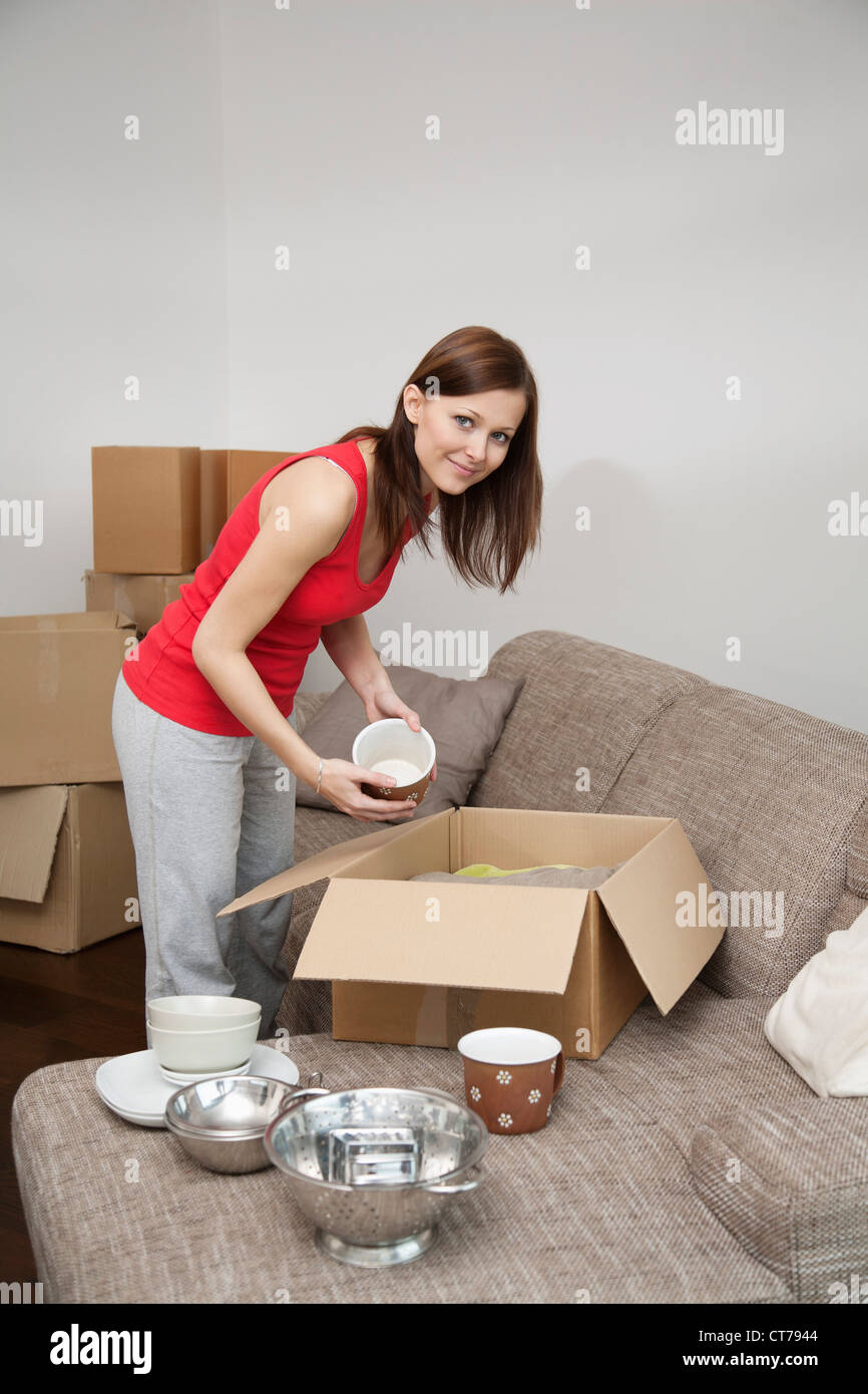 young woman packing crockery in moving box Stock Photo Alamy