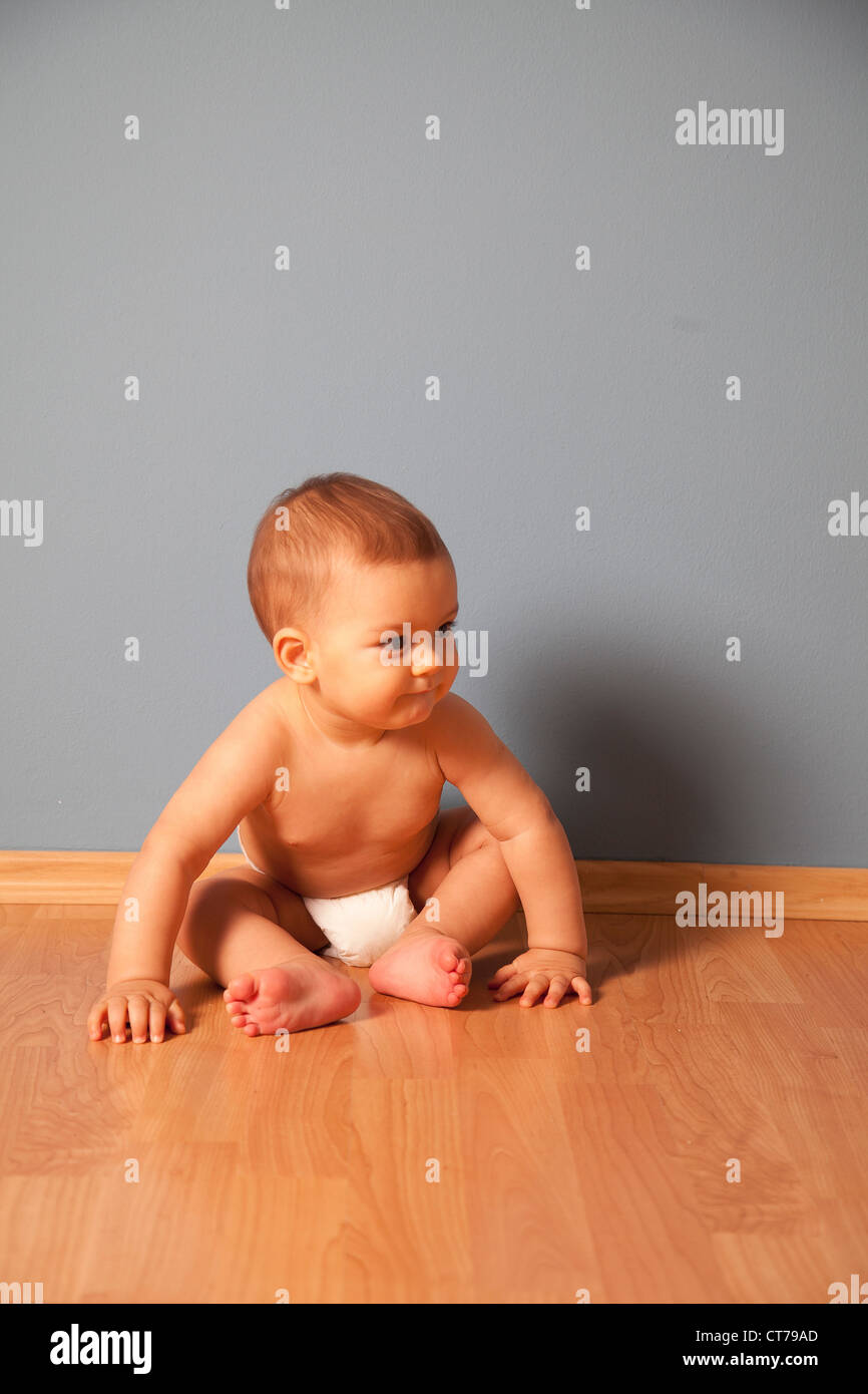 portrait of baby wearing nappy sitting on floor Stock Photo Alamy
