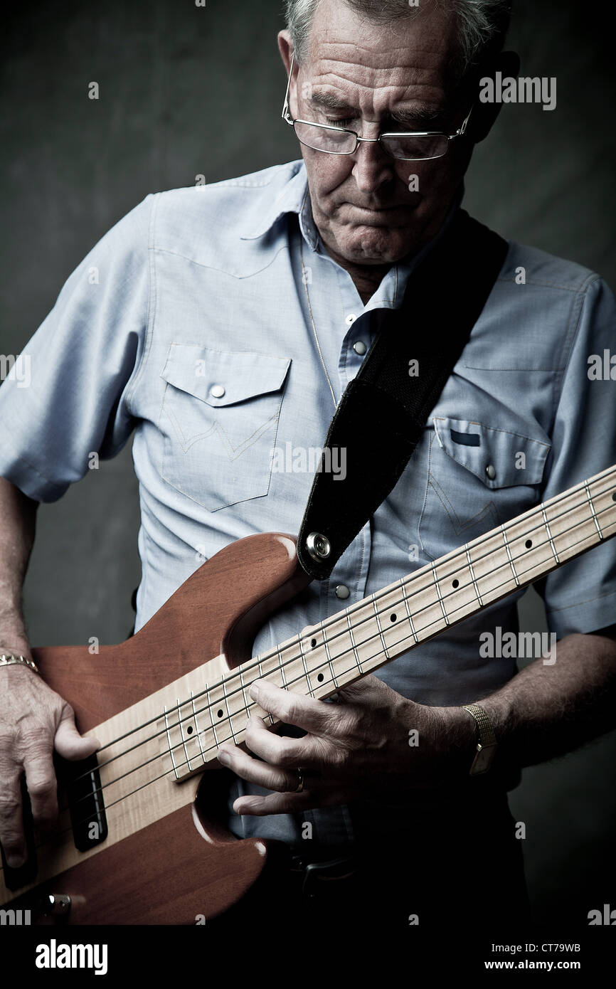 Senior man playing bass guitar Stock Photo