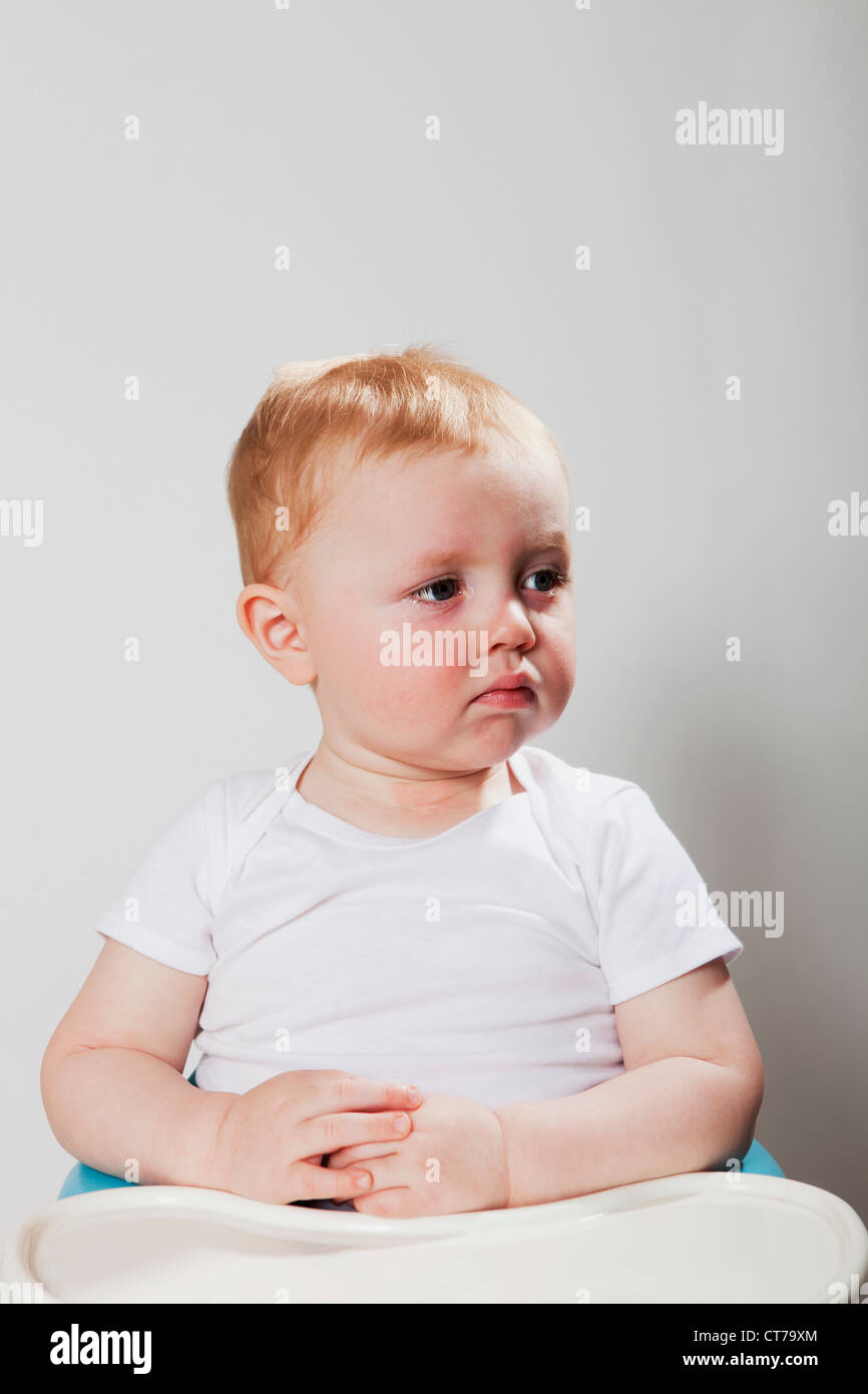 Baby boy sitting in high chair Stock Photo Alamy