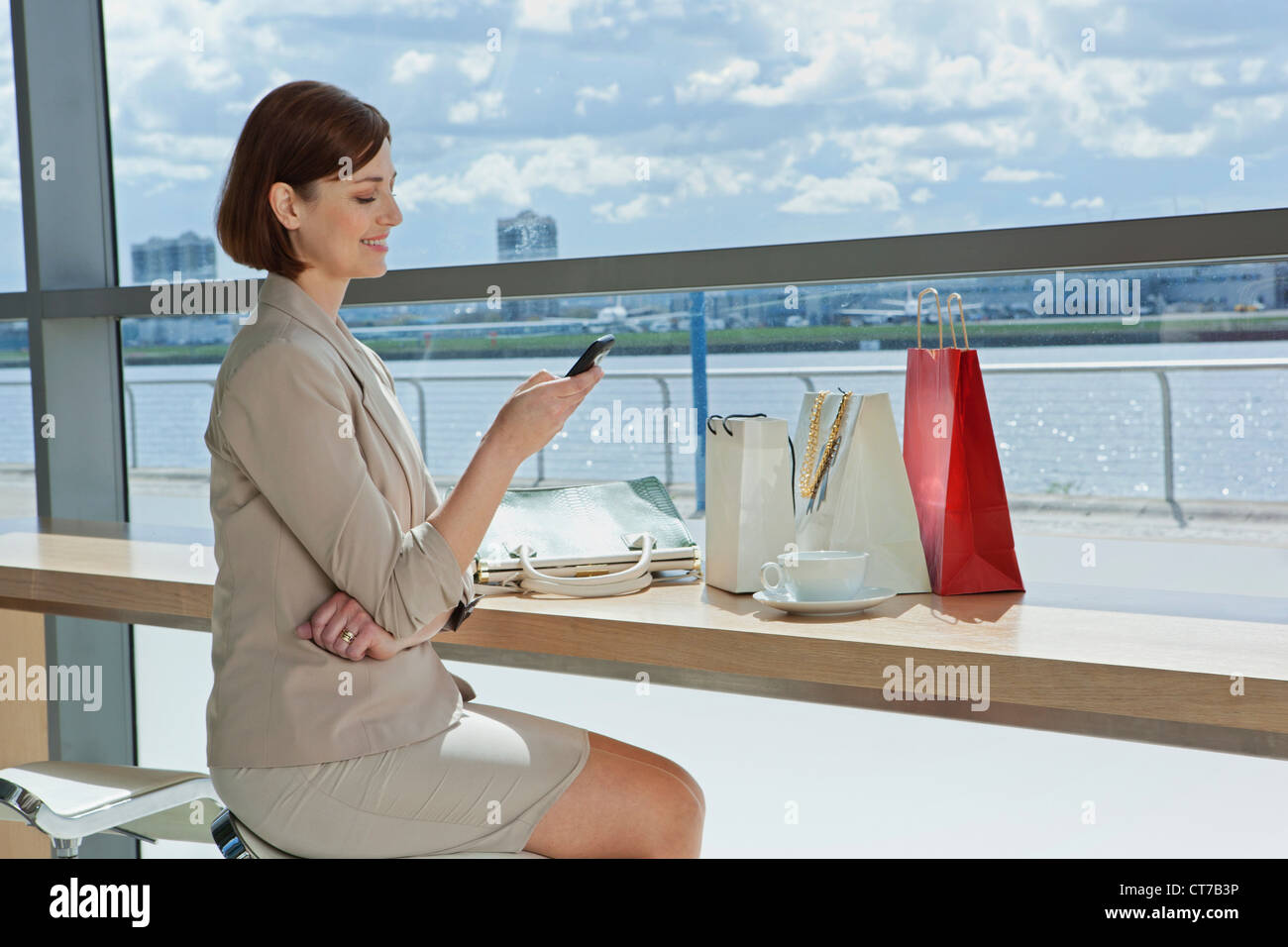 Mid adult woman texting in airport Stock Photo - Alamy