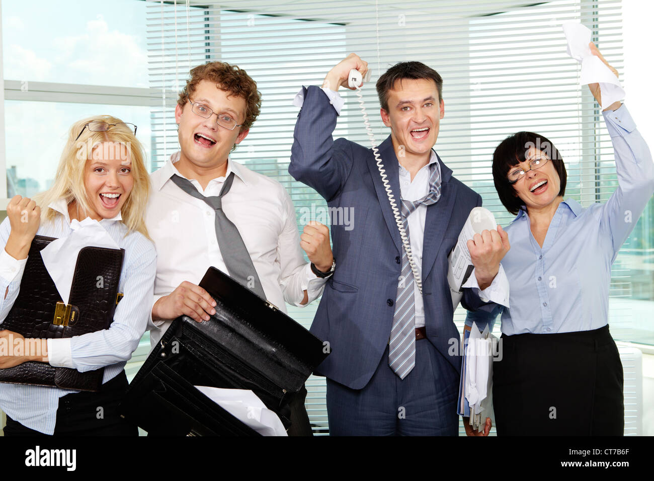 Group of tired businesspeople showing gladness after making excellent deal Stock Photo