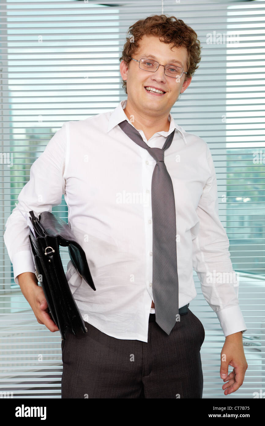 Sloppy businessman with briefcase looking at camera Stock Photo