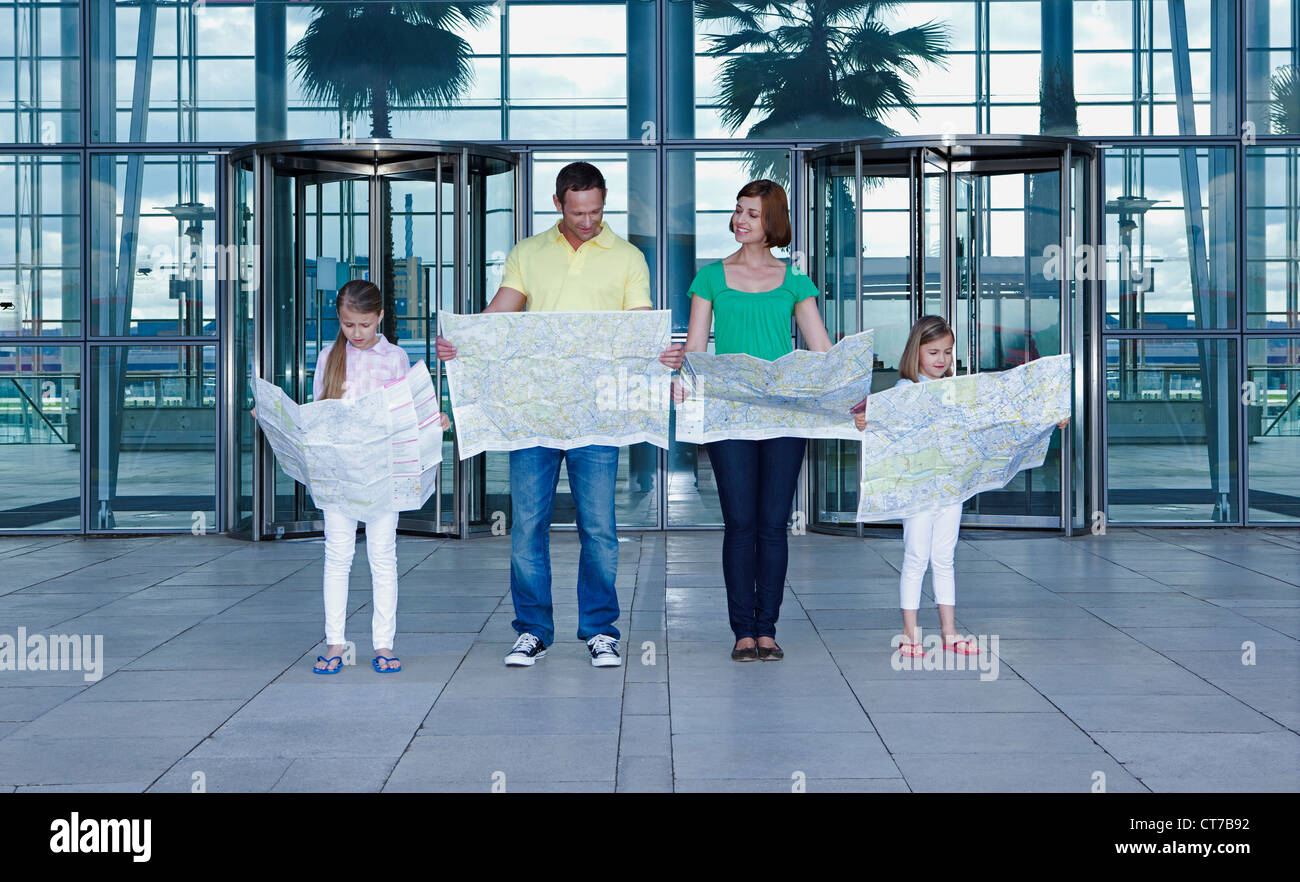 Family with maps outside airport Stock Photo - Alamy