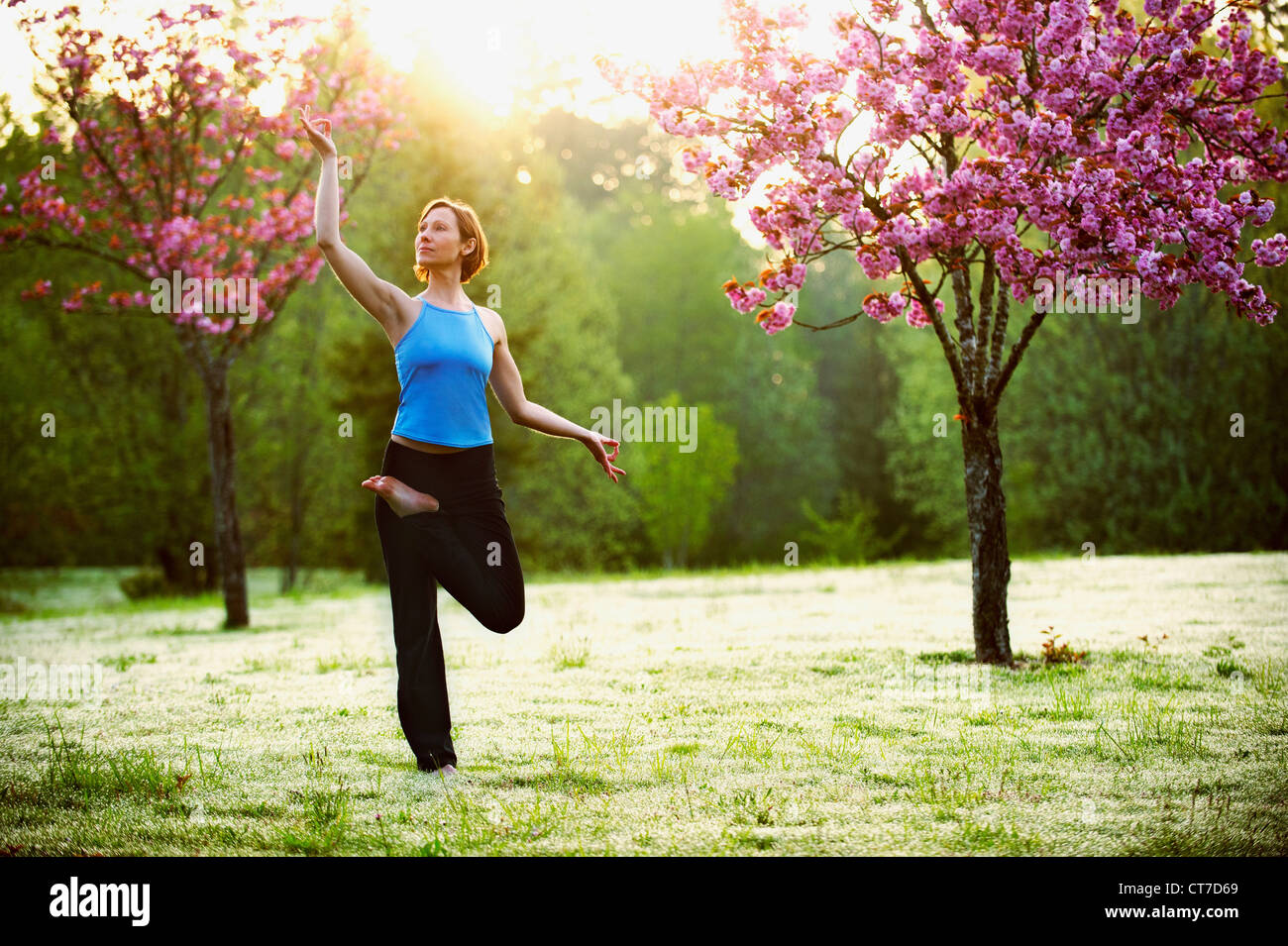 Woman in yoga pose in park Stock Photo - Alamy