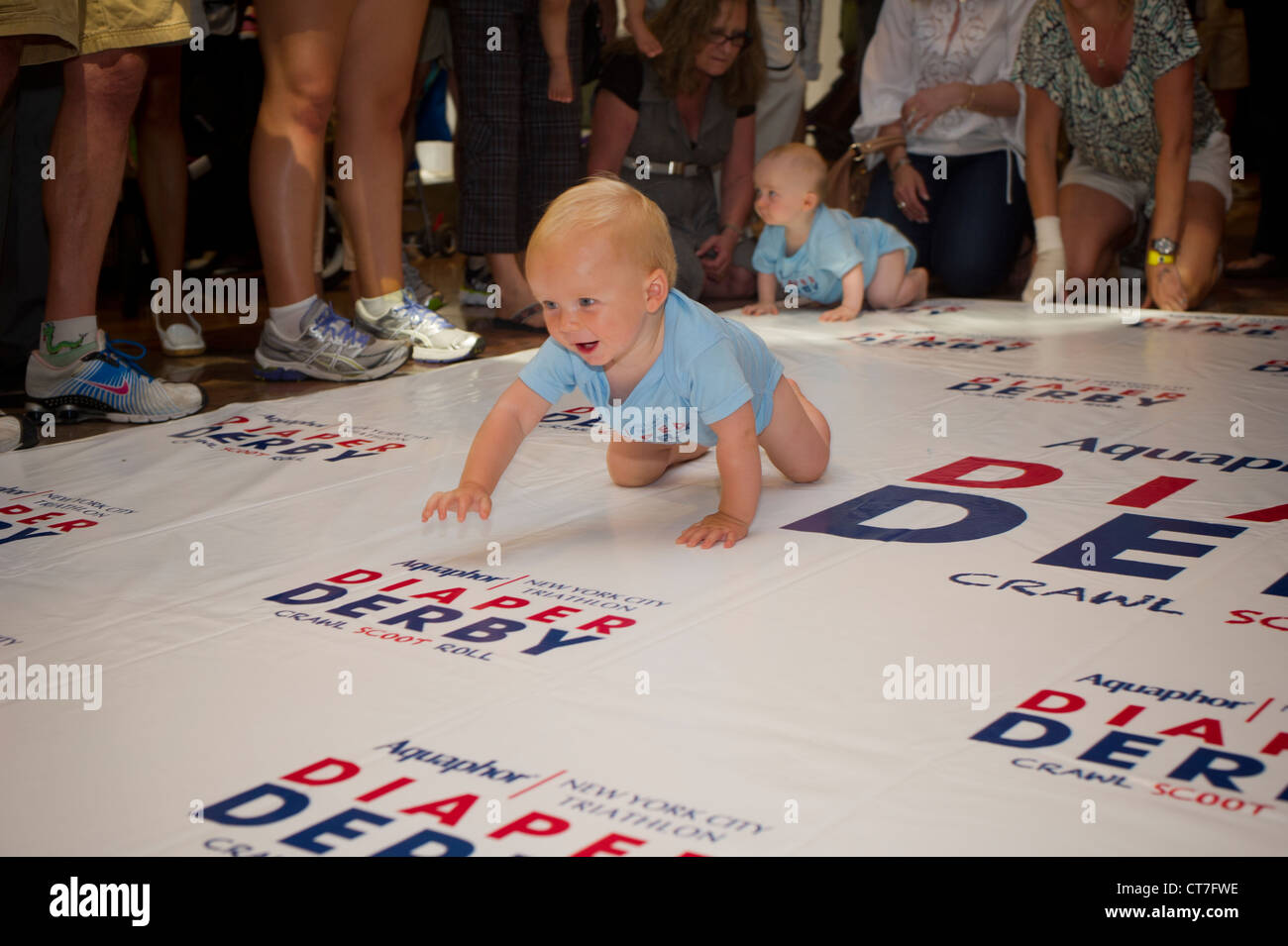 Babies crawl to the finish line in a Diaper Derby in New York Stock