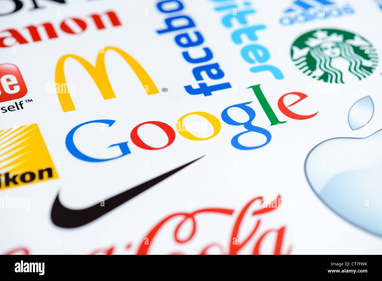 Close up photo of the Google logo on the printed paper together with a collection of well-known brands of the world. Stock Photo