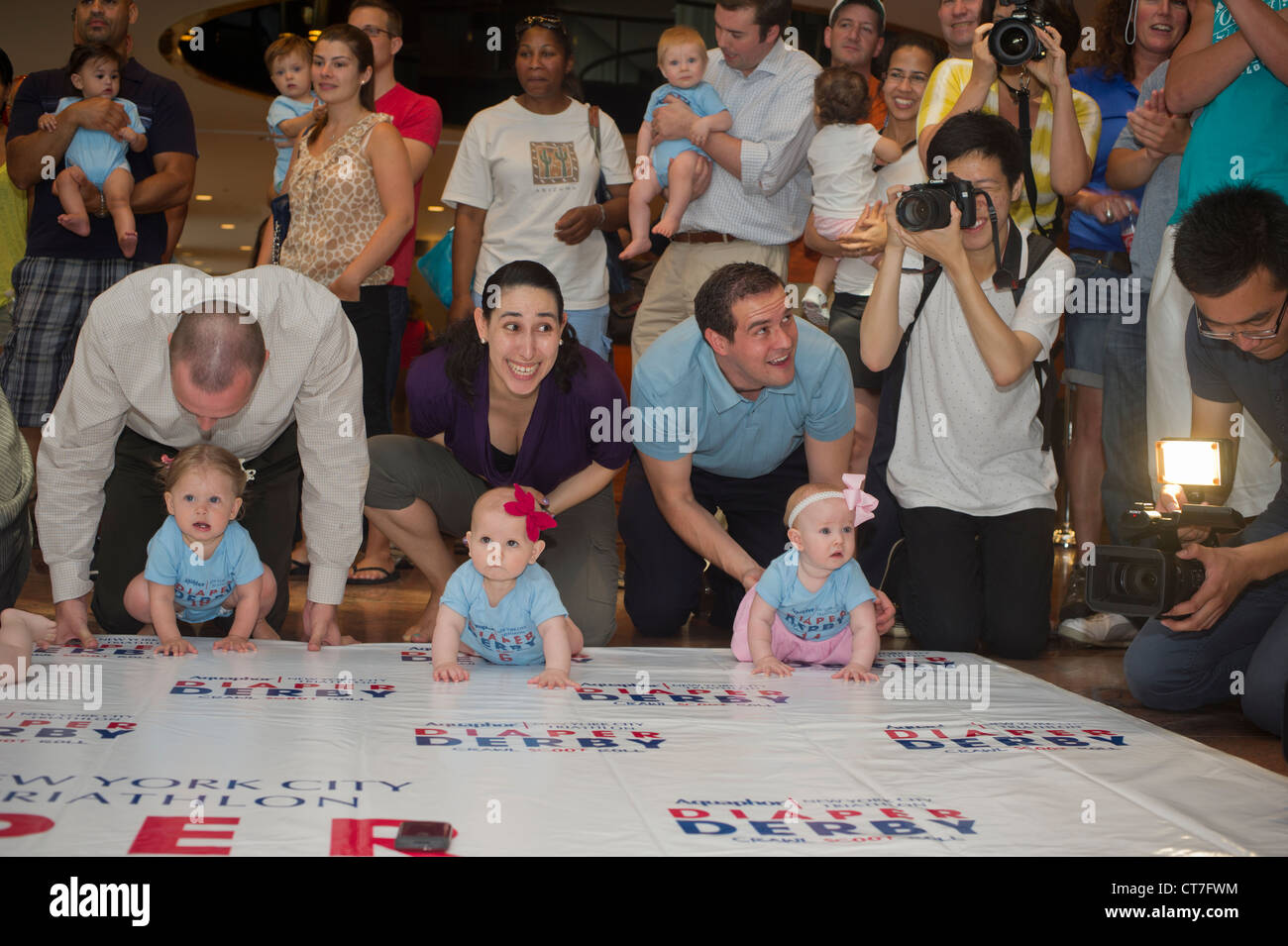 Babies crawl to the finish line in a Diaper Derby in New York Stock Photo