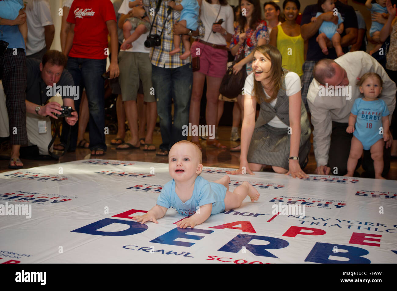 Babies crawl to the finish line in a Diaper Derby in New York Stock Photo