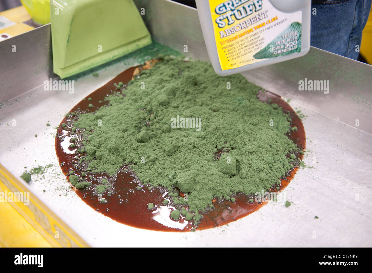 Hazardous materials absorbent 'Green Stuff' is used on sample oil and antifreeze at an environmental quality trade show. Stock Photo