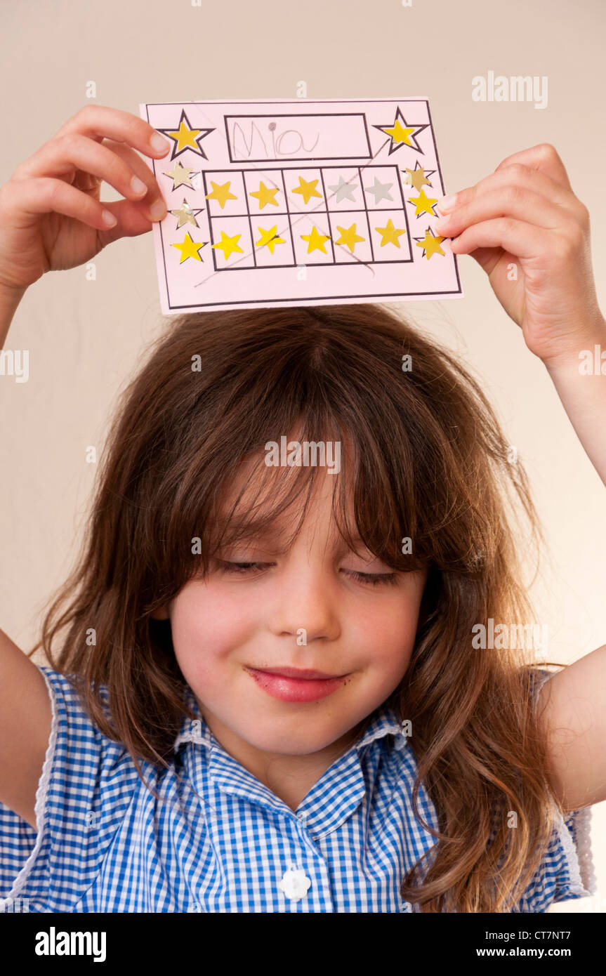 Child with completed sticker reward chart. Stock Photo