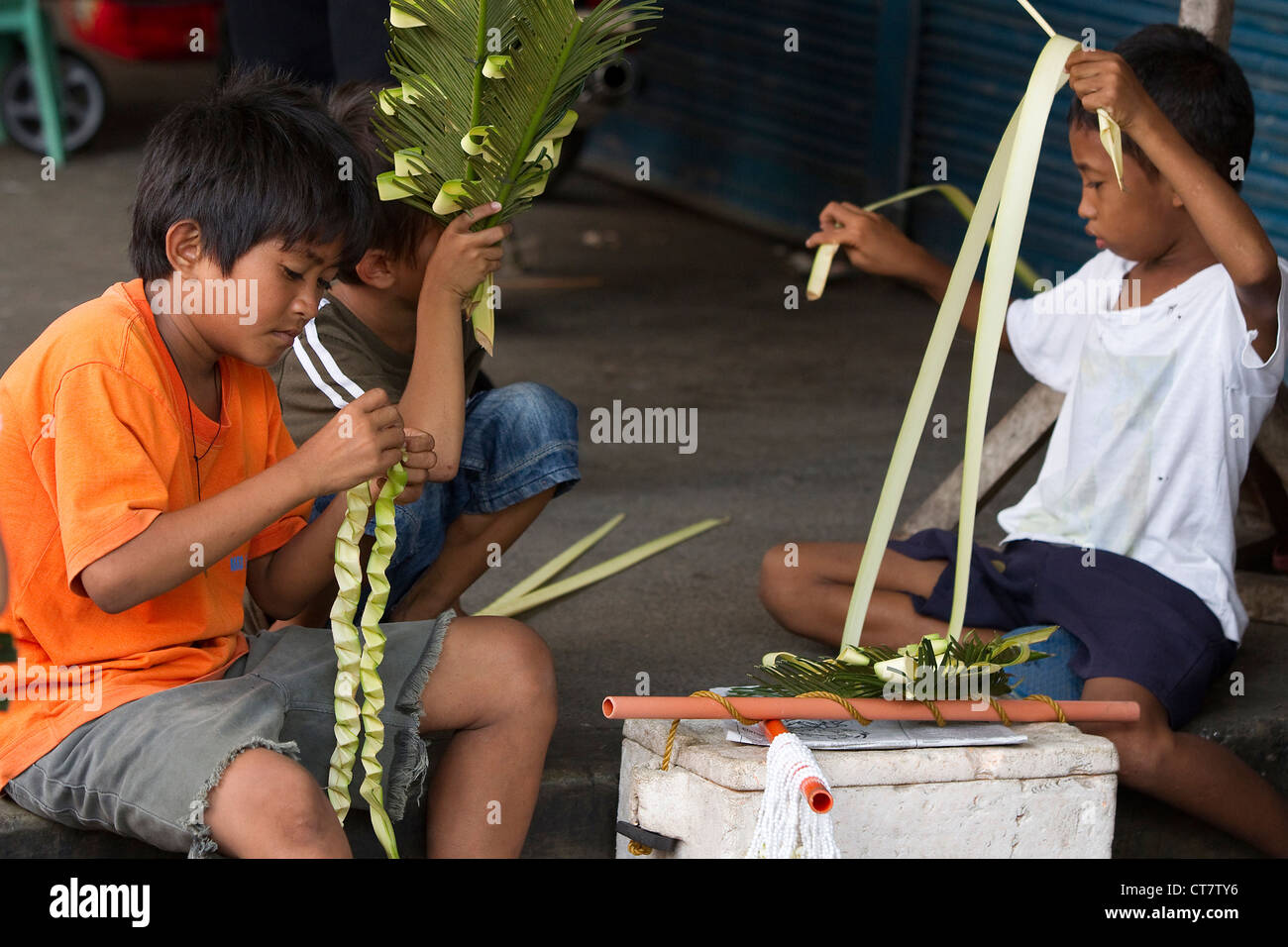 Young Filipino children make Palm crosses for Palm Sunday,Holy Week Philippines 2012 Stock Photo