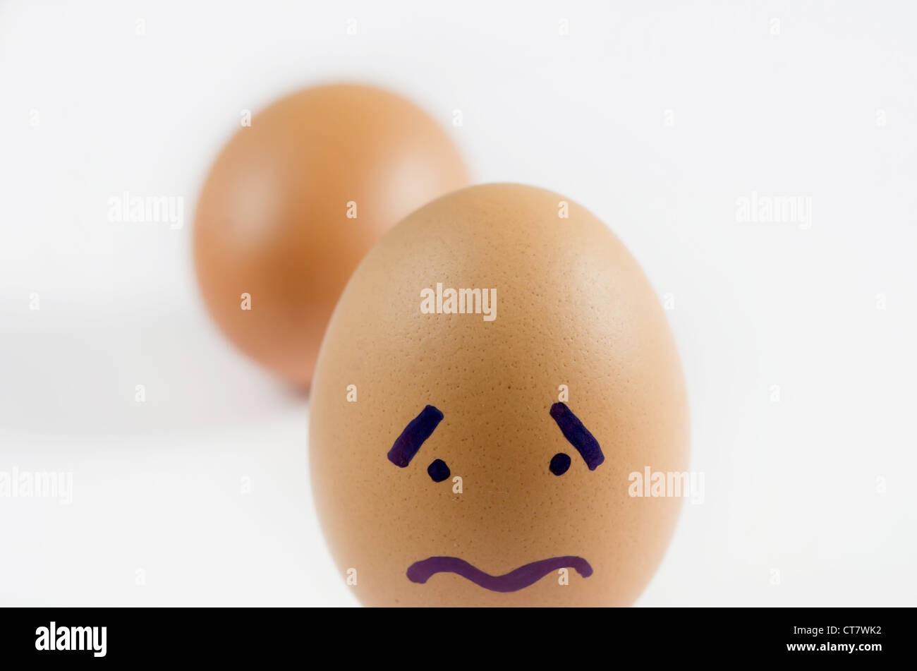 close-up brown eggs with sad face on white background Stock Photo