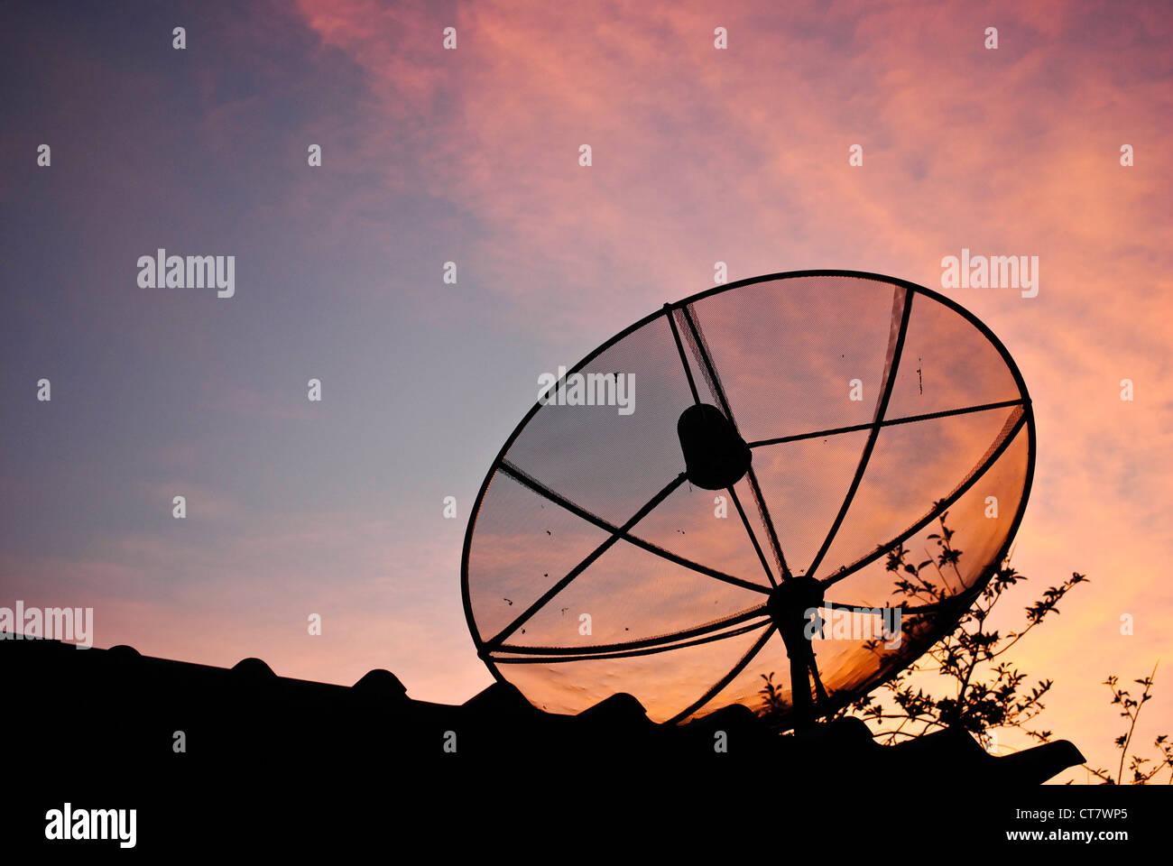 Satellite dish in evening sky Stock Photo