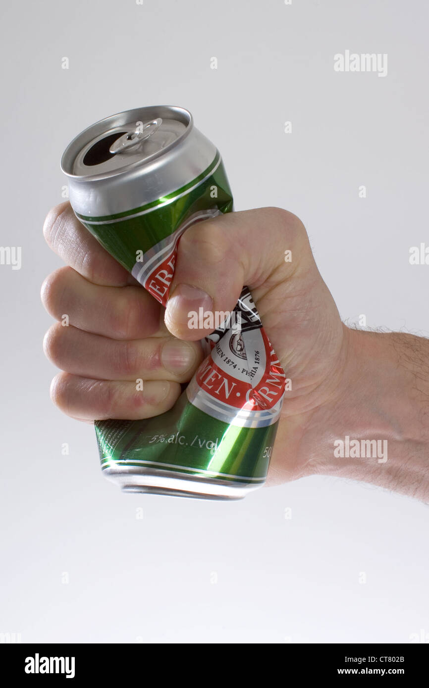 Symbol photo, a beer can is crushed by hand Stock Photo