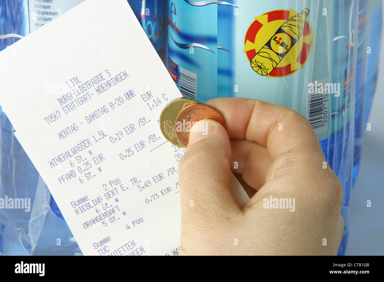 Hand with money and deposit receipt before bottles of LIDL Stock Photo