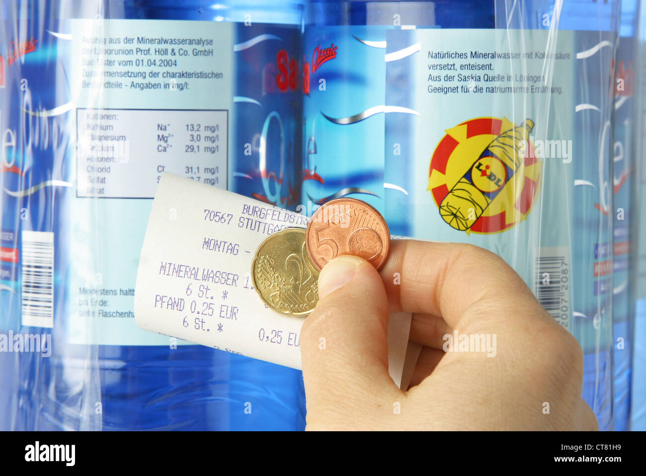 Hand with money and deposit receipt before bottles of LIDL Stock Photo