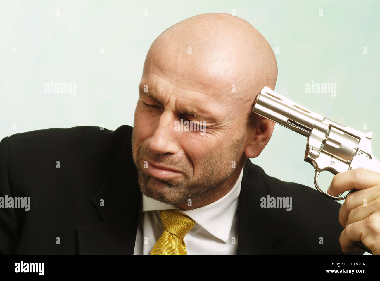 Man aiming a gun at himself Stock Photo