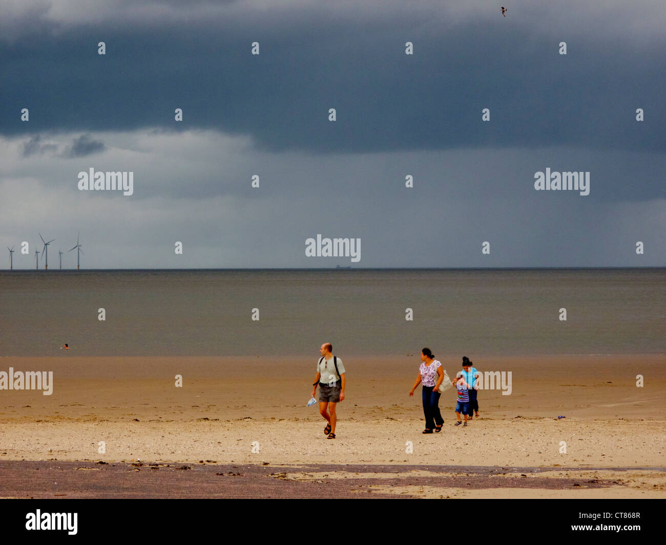 New Brighton, end of season. Sept 2011. Merseyside seaside resort. Family leaving beach due to rain. Stock Photo