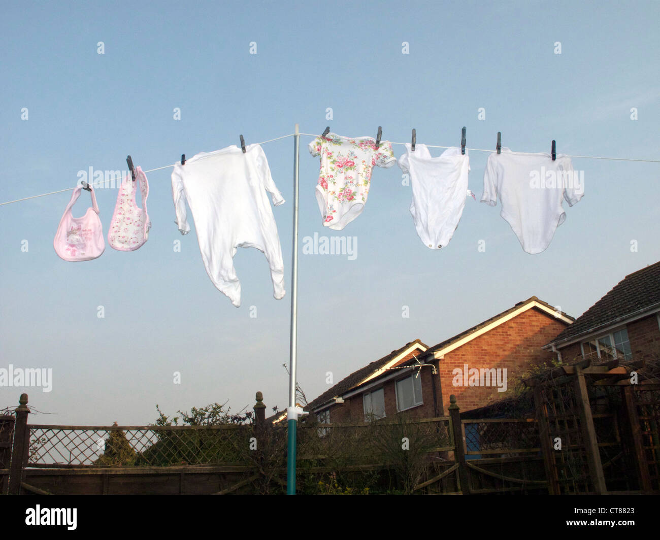 baby clothes hung on washing line Stock Photo