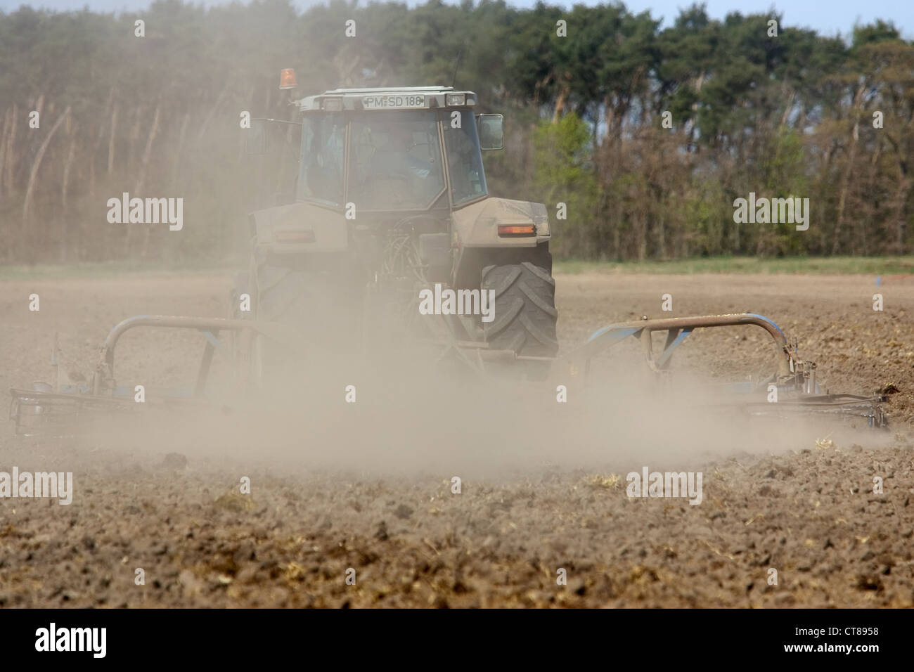 Brandenburg, a tractor harrowing on the field Stock Photo - Alamy