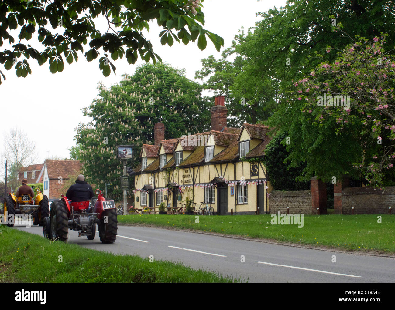 George and Dragon public house in Sutton Courtenay, Oxfordshire. Two tractors drive past. Stock Photo