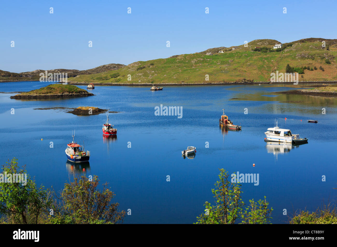 View of boats moored in calm blue waters of Badcall Bay on Scottish west coast near Scourie, Sutherland, Highland, Scotland, UK Stock Photo