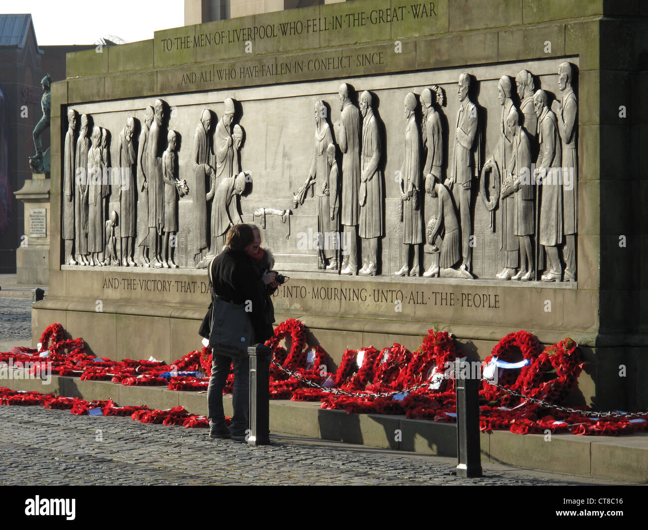 Liverpool Cenotaph, St George's Hall, Liverpool. A couple view the Remembrance Day Poppy Wreaths Stock Photo