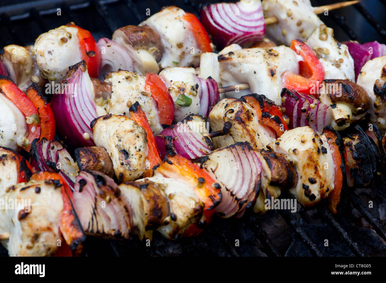 cooked chicken and vegetable kebabs on a barbecue Stock Photo