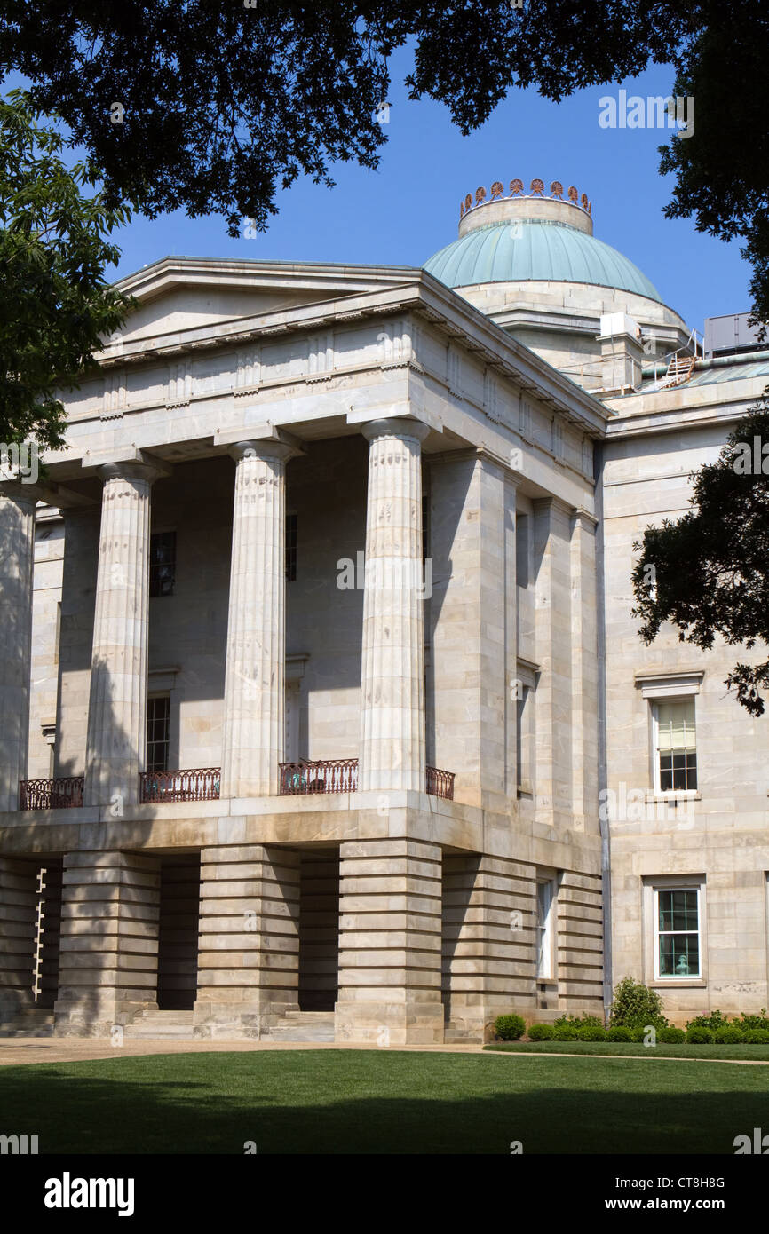 North Carolina Capitol building in the city of Raleigh, North Carolina, USA framed by trees with dome against a blue sky. Stock Photo