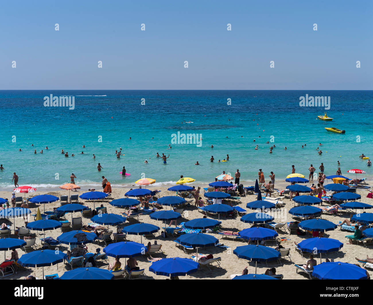 dh Grecian Bay AYIA NAPA CYPRUS Holiday in Sun umbrellas sand beach sunbathers and swimmers beaches tourism Stock Photo