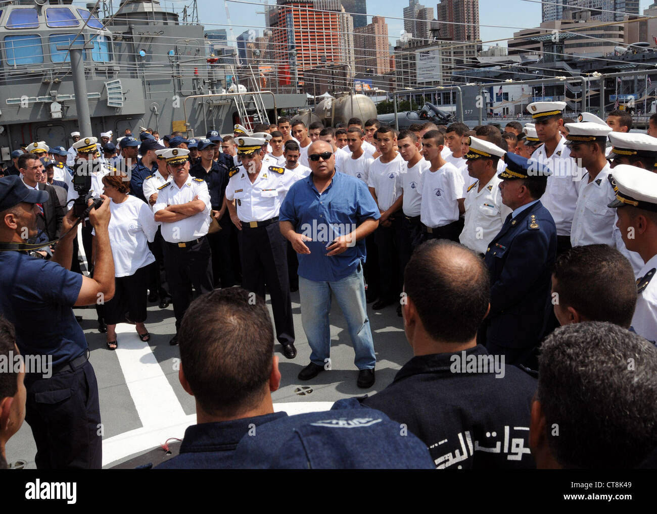 Detective Inspector Frank D'Arsillo from the New York Police Department conducts a safety brief for the crew of Algerian navy ship Soummam (937), as part of their port visit. This marks the first time an Algerian navy ship has visited the United States. During their visit, the Algerian crew will tour the city and conduct office calls with city and government officials. The Soummam transited the Atlantic from Algeria as part of a training mission for Algerian naval academy students. Stock Photo