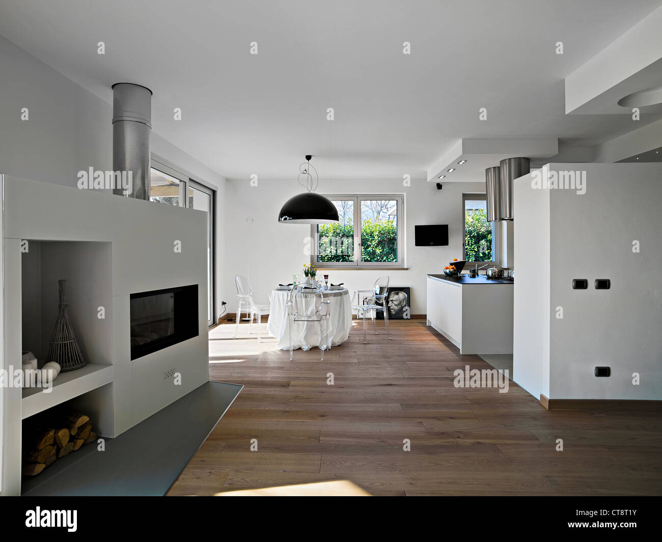 modern dining room with kitchen view and fireplace Stock Photo