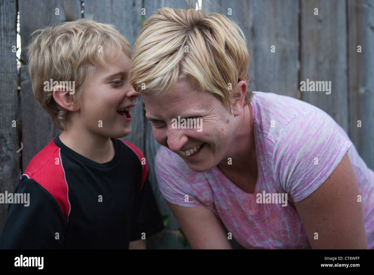 Ten year old boy telling his mother a story and mom laughing outloud. Stock Photo