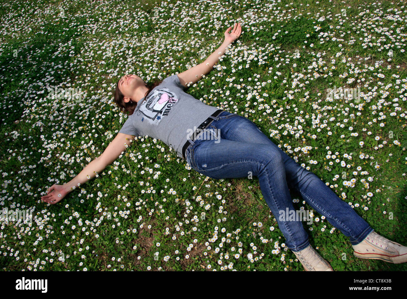 Young woman laying in flowers Stock Photo